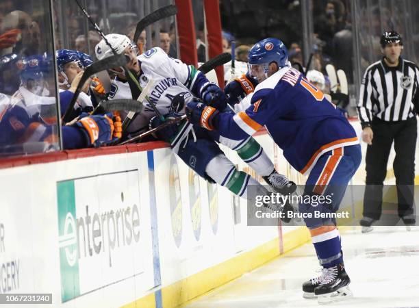 Thomas Hickey of the New York Islanders checks Brendan Leipsic of the Vancouver Canucks during the third period at the Barclays Center on November...