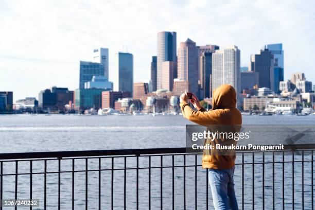 new york city, brooklyn, man with cell phone standing at the waterfront - boston massachusetts fall stock pictures, royalty-free photos & images