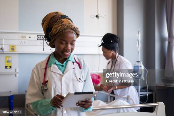 control de registros de pacientes en una tableta digital - áfrica fotografías e imágenes de stock