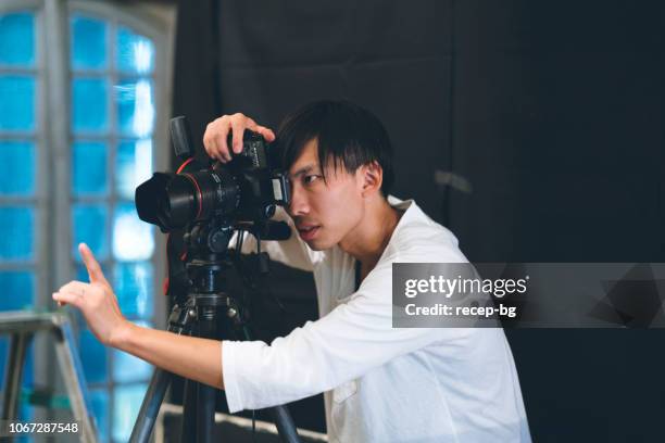 photograher profesional tomando fotos en su estudio - capturar una imagen fotografías e imágenes de stock