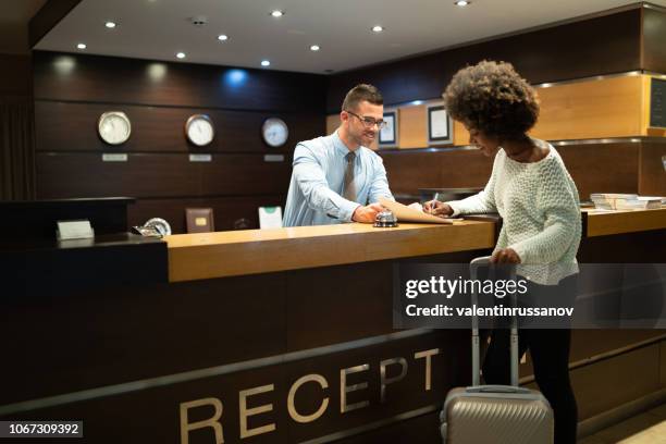 tourist register in hotel - african ethnicity luxury stock pictures, royalty-free photos & images