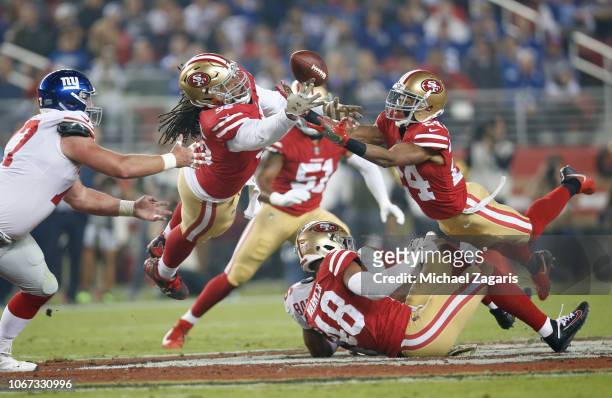 Sheldon Day and K'Waun Williams of the San Francisco 49ers dive for a batted ball along with Spencer Pulley of the New York Giants during the game at...