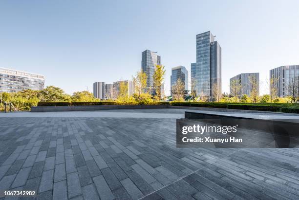 pedestrian walkway toward modern skyscrapers - büropark stock-fotos und bilder