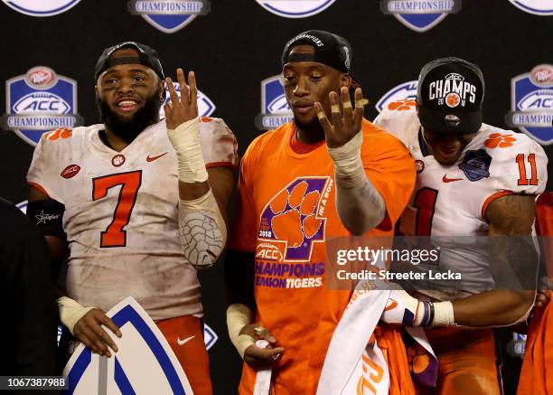 Austin Bryant and teammates Clelin Ferrell and Isaiah Simmons of the Clemson Tigers signal four ACC Championships in a row after their 42-10 victory...