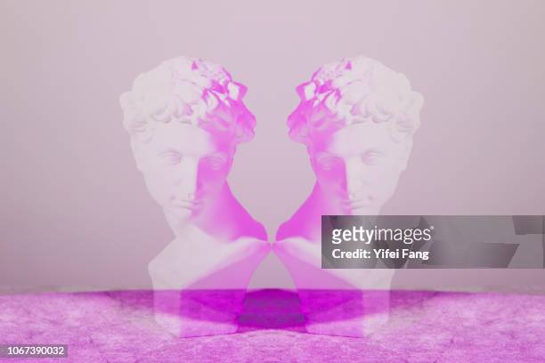 mirrored image of sculpture facing each other - ijdel stockfoto's en -beelden