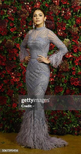 Indian Bollywood actress Anushka Sharma poses for a picture during the wedding reception party of actors Ranveer Singh and Deepika Padukone in Mumbai...