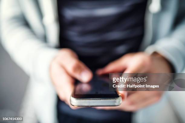a close-up of unrecognizable young sporty man with smartphone standing in the city. - unrecognizable person stock pictures, royalty-free photos & images