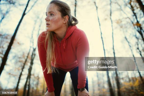 exhausted woman after jogging in autumnal park. - mujer cansada fotografías e imágenes de stock