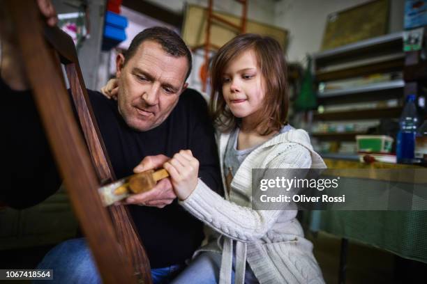 father and daughter working on a chair together in a workshop - ausbildung und tischler stock-fotos und bilder