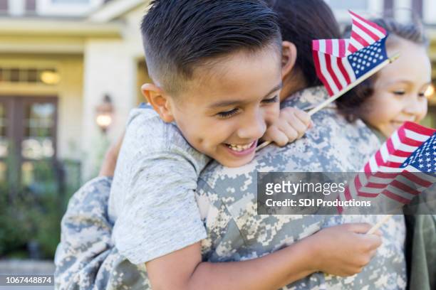i bambini sono entusiasti di riunirsi con la mamma dell'esercito - rinviare la palla foto e immagini stock