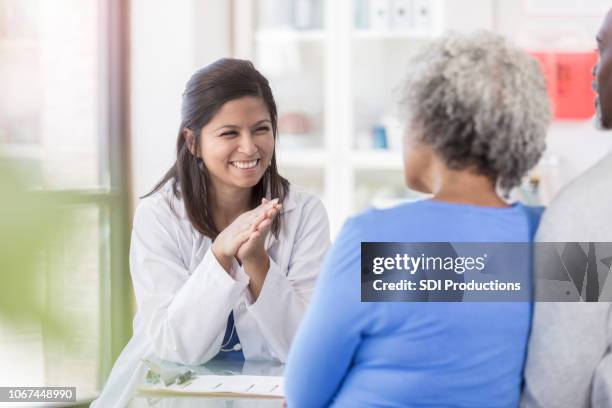 female doctor enjoys giving patients good news - senior couple funny imagens e fotografias de stock