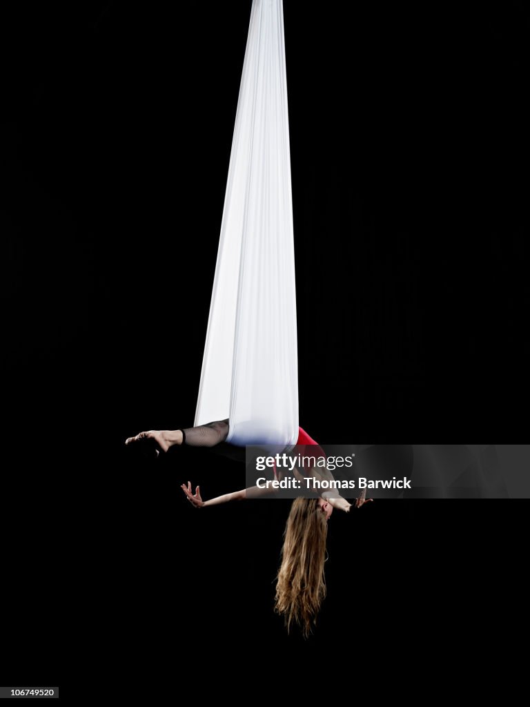 Female aerialist performing on suspended silk