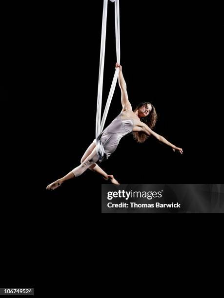 female aerialist performing on suspended silk - circus performer fotografías e imágenes de stock