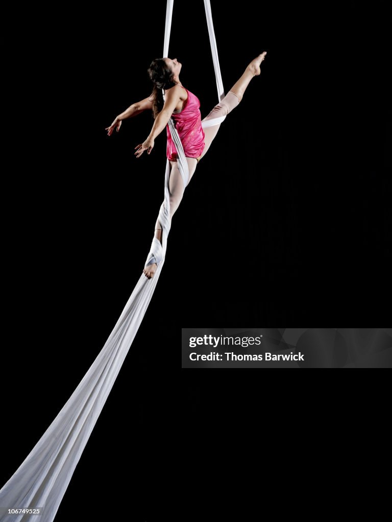 Female aerialist performing on suspended silk