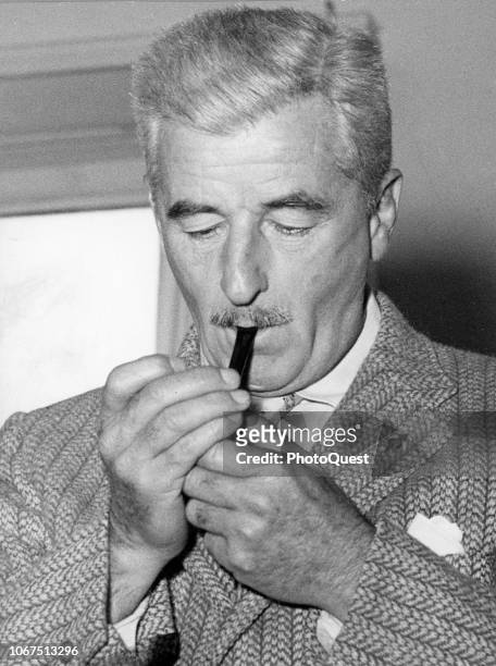 View of Pulitzer Prize-winning author William Faulkner as he lights his pipe, Oxford, Mississippi, 1957.