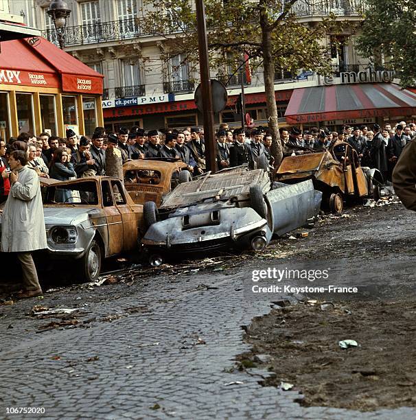 During A Student Demonstration On Boulevard Saint Michel In Paris, Members Of The Crs Were Positioned Behind Burnt Out Cars At The Corner Of Rue...