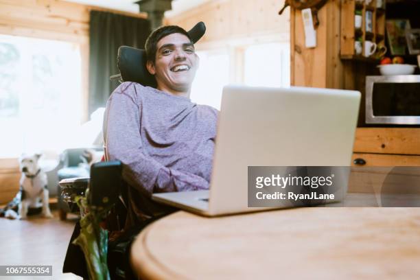confident young man in wheelchair at home - persons with disabilities stock pictures, royalty-free photos & images