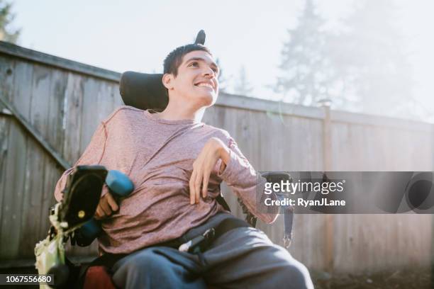 自信的年輕人在家裡坐輪椅 - developmental disability 個照片及圖片檔