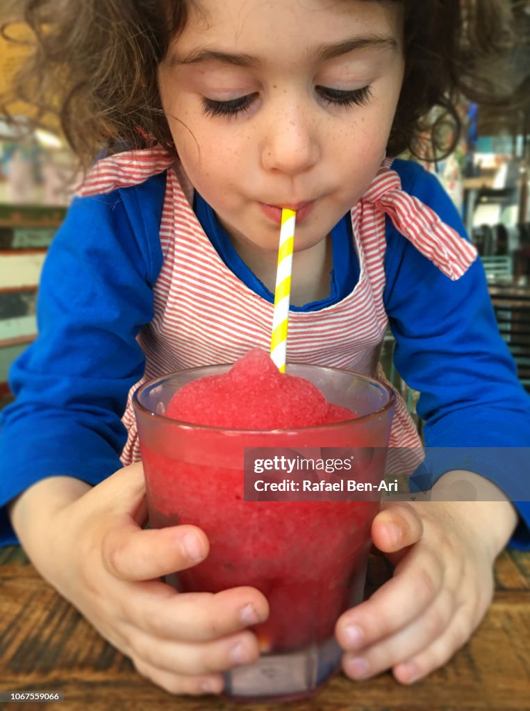 Young girl Drinking a Frozen Raspberry Drink