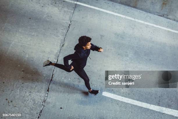 young woman running on the streets - road running stock pictures, royalty-free photos & images