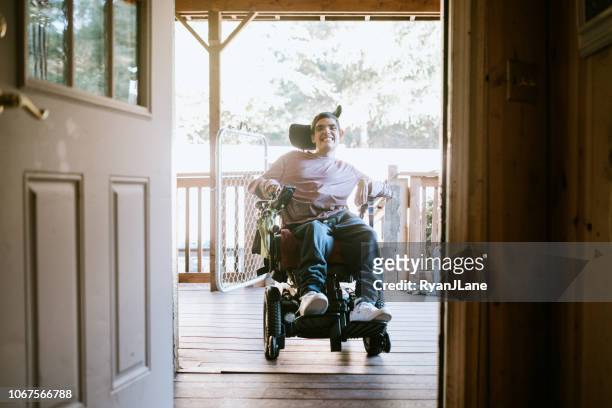 confident young man in wheelchair at home - disabled accessibility stock pictures, royalty-free photos & images