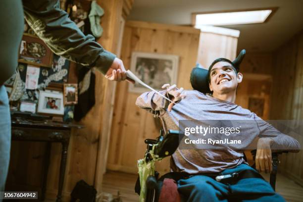 zelfverzekerde jonge man in rolstoel thuis - disabilitycollection stockfoto's en -beelden