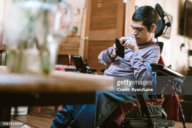 confiado joven en silla de ruedas en casa - reconocimiento del habla fotografías e imágenes de stock