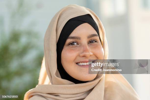 smiling young muslim woman looking at the camera - moroccan girl stock pictures, royalty-free photos & images