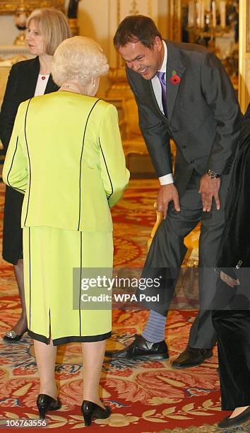 Entrepreneur Peter Jones shows Queen Elizabeth II his striped socks at the annual Civil Service Awards Reception, at Buckingham Palace, November 11,...