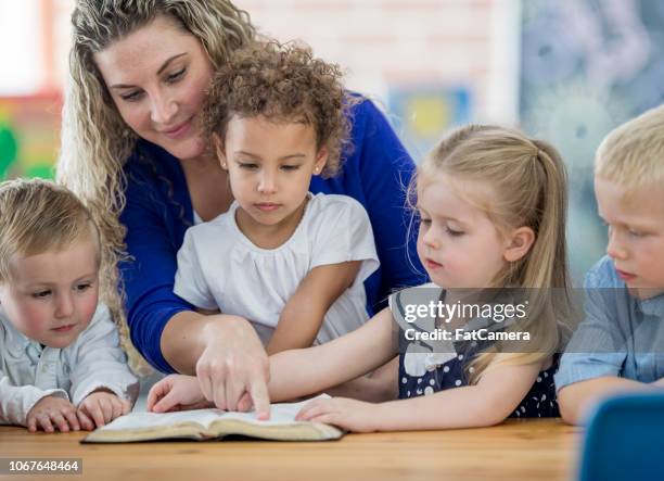 sunday school teacher and pupils - kids reading in classroom stock pictures, royalty-free photos & images