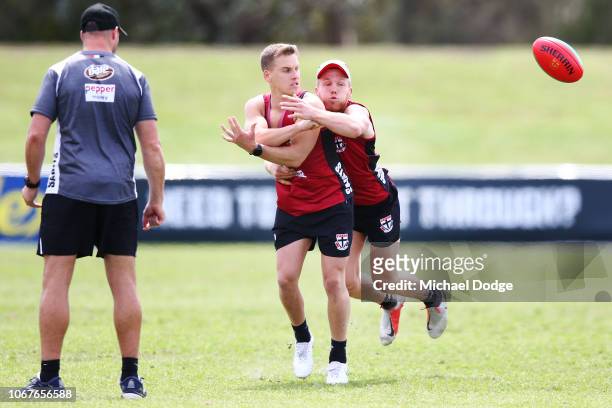 Dan Hannebery tackles Jack Lonie as assistant coach Brendan Lade taps the ball during a St Kilda Saints AFL Media Opportunity at Moorabbin Oval on...
