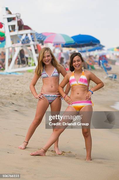 two young girls posing on the beach. - tween girl swimsuit stock-fotos und bilder