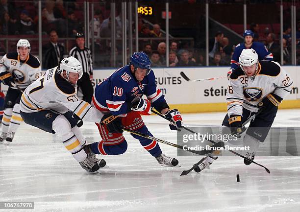 Tyler Myers and Thomas Vanek of the Buffalo Sabres trip up Marian Gaborik of the New York Rangers at Madison Square Garden on November 11, 2010 in...