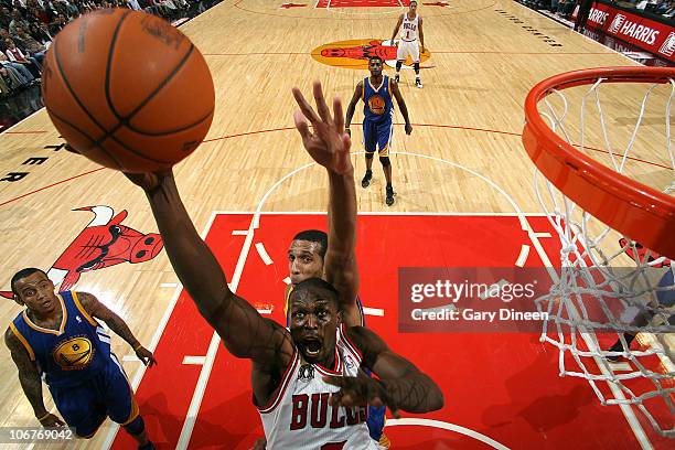 Luol Deng of the Chicago Bulls goes to the basket past Brandan Wright AND Monta Ellis of the Golden State Warriors during the NBA game on November...