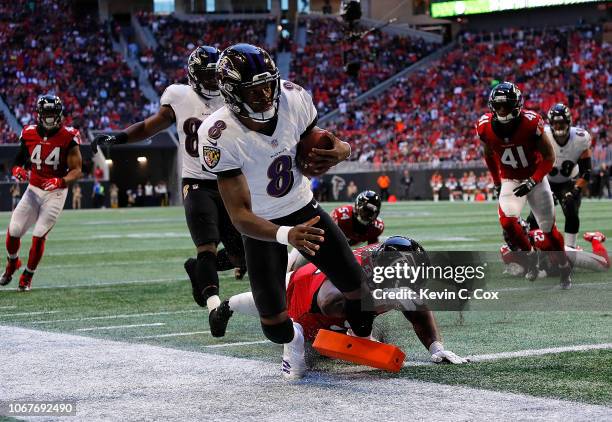 Lamar Jackson of the Baltimore Ravens rushes for a touchdown past Grady Jarrett of the Atlanta Falcons at Mercedes-Benz Stadium on December 2, 2018...