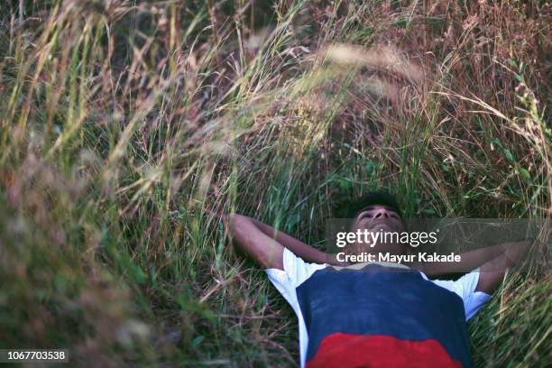 teenage boy relaxing in the grass - long grass bildbanksfoton och bilder