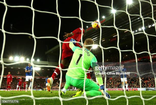 Divock Origi of Liverpool scores his team's first goal past Jordan Pickford of Everton during the Premier League match between Liverpool FC and...