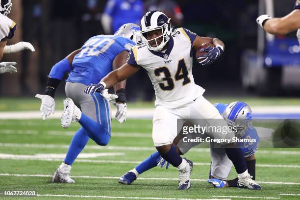Malcolm Brown of the Los Angeles Rams runs for yardage against Darius Slay of the Detroit Lions and Jarrad Davis during the first half at Ford Field...