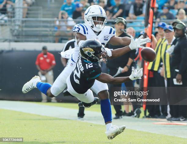 Dede Westbrook of the Jacksonville Jaguars and Kenny Moore of the Indianapolis Colts battle for the football during their game at TIAA Bank Field on...