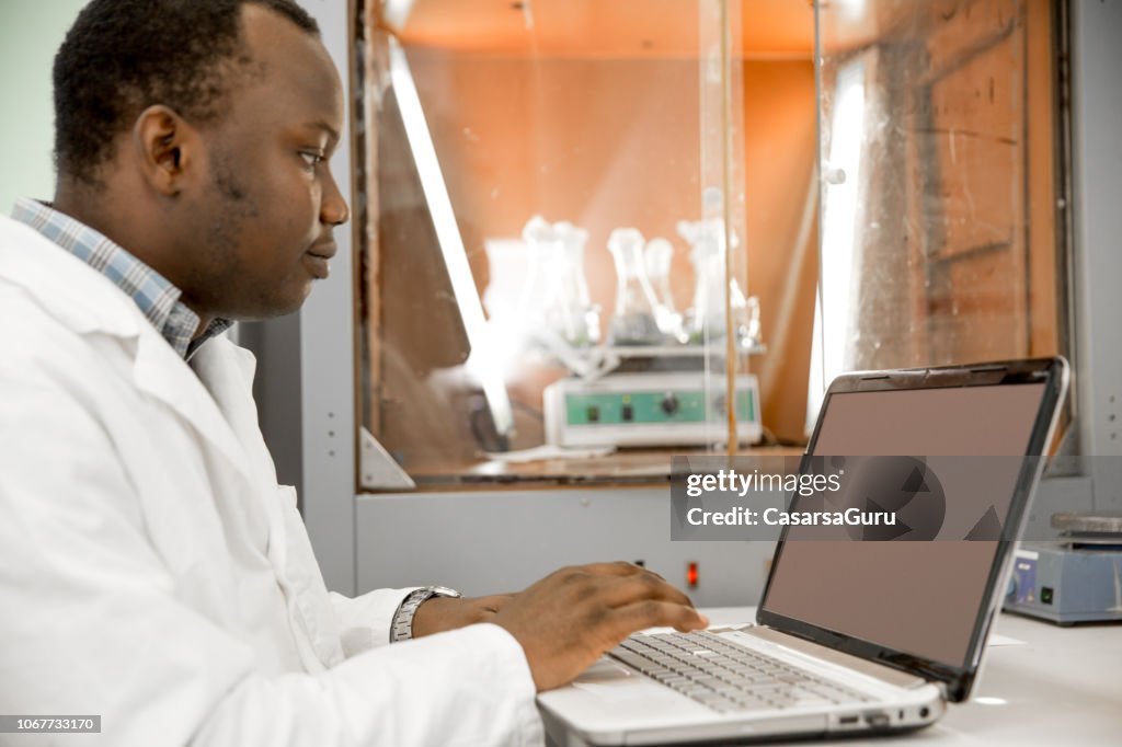 African Researcher Using Laptop In Laboratory High-Res Stock Photo ...