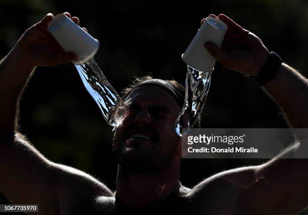 Runner throws water on his face to cool off in a water station during Humana Rock 'n' Roll San Antonio Marathon and 1/2 Marathon on December 2, 2018...