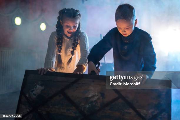 i bambini stanno aprendo il vecchio scrigno del tesoro - scatola del tesoro foto e immagini stock