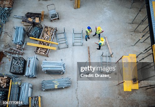 High angle view on construction site and three engineers High angle view on construction site and three engineers