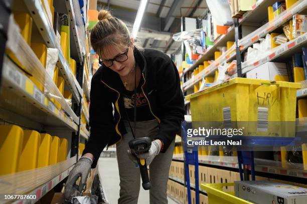 Member of staff picks customer orders from the storage shelves at the Amazon Fulfillment Centre on November 14, 2018 in Hemel Hempstead, England. The...