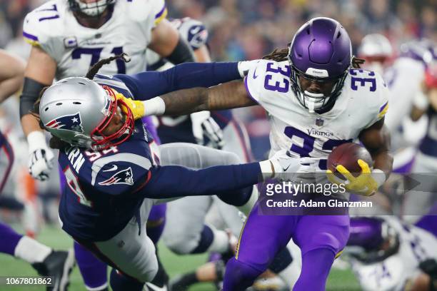 Dalvin Cook of the Minnesota Vikings stiff arms Adrian Clayborn of the New England Patriots during the second half at Gillette Stadium on December 2,...