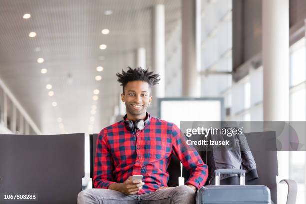 jonge afrikaanse man vlucht wachten in de luchthaven lounge - airport hipster travel stockfoto's en -beelden