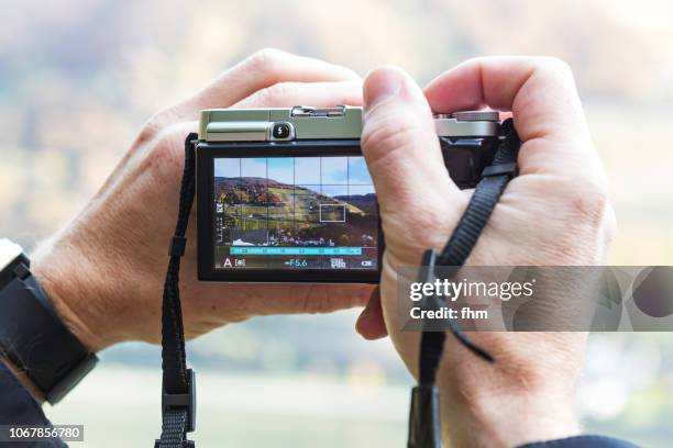 two hands hold a camera with landscape motif on display - digital viewfinder stock pictures, royalty-free photos & images