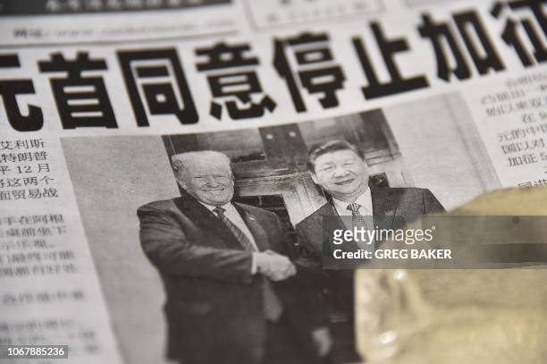 Newspaper featuring a front page story about the meeting between US President Donald Trump and Chinese President Xi Jinping as seen at a news stand...