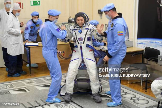 Russian cosmonaut Oleg Kononenko, a member of the International Space Station expedition 58/59, is helped by specialists as his space suit is tested...