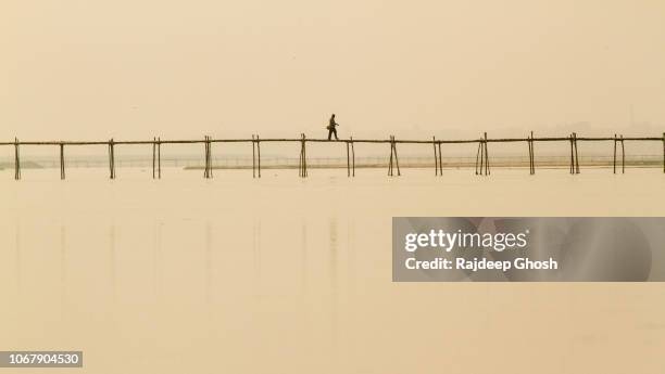 a man walks over bridge in rural india - kolkata bridge stock pictures, royalty-free photos & images